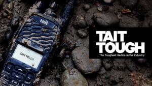 Tait Tough Logo, Tait Tough Portable radio on the ground surround by mud.