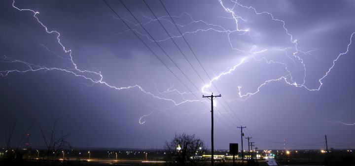 Power Pole Illuminated by lightning in the night sky