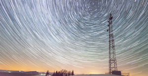 Radio Antenna against a long exposure of the night sky, with stars spinning in a visual circle motion